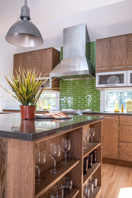 Kitchen with stained cabinets and tile backsplash under the range hood.