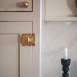 Painted cabinet. Image highlights a candle and gold cabinet hardware.