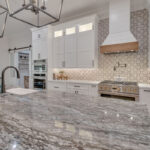 White kitchen with stained accent apron on hood.