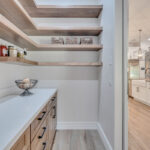 Pantry with stained cabinets and floating shelves.