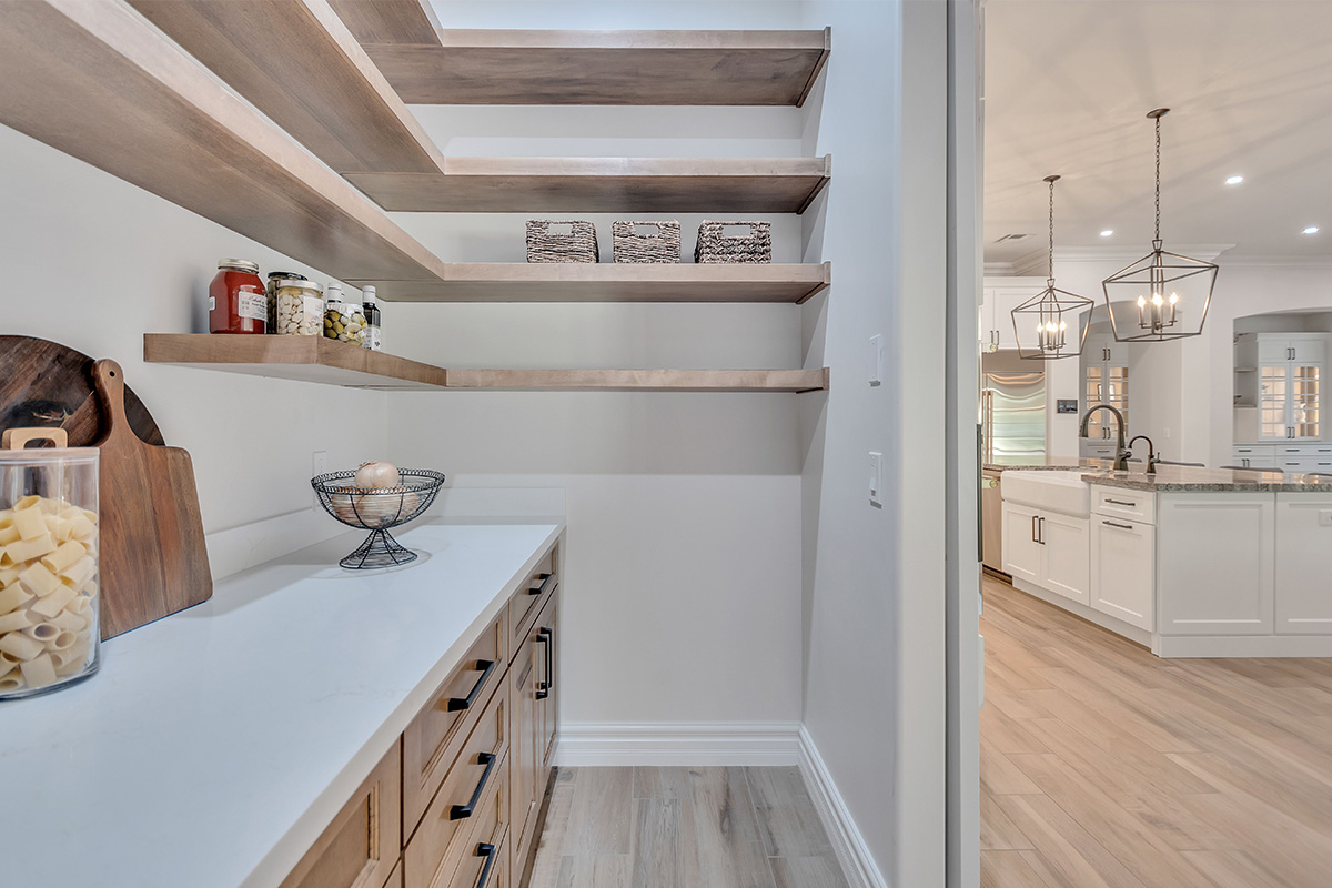 Pantry with stained cabinets and floating shelves.