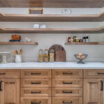 Pantry with stained cabinets and floating shelves.