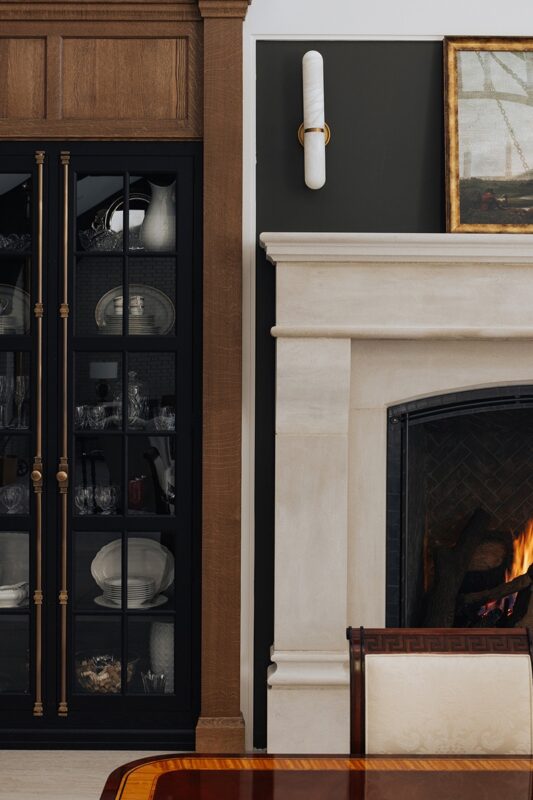 black painted cabinet next to a fireplace