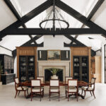 Large open kitchen space with wood beams and stained and painted cabinets