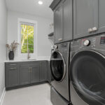 Painted laundry room cabinets and washer/dryer