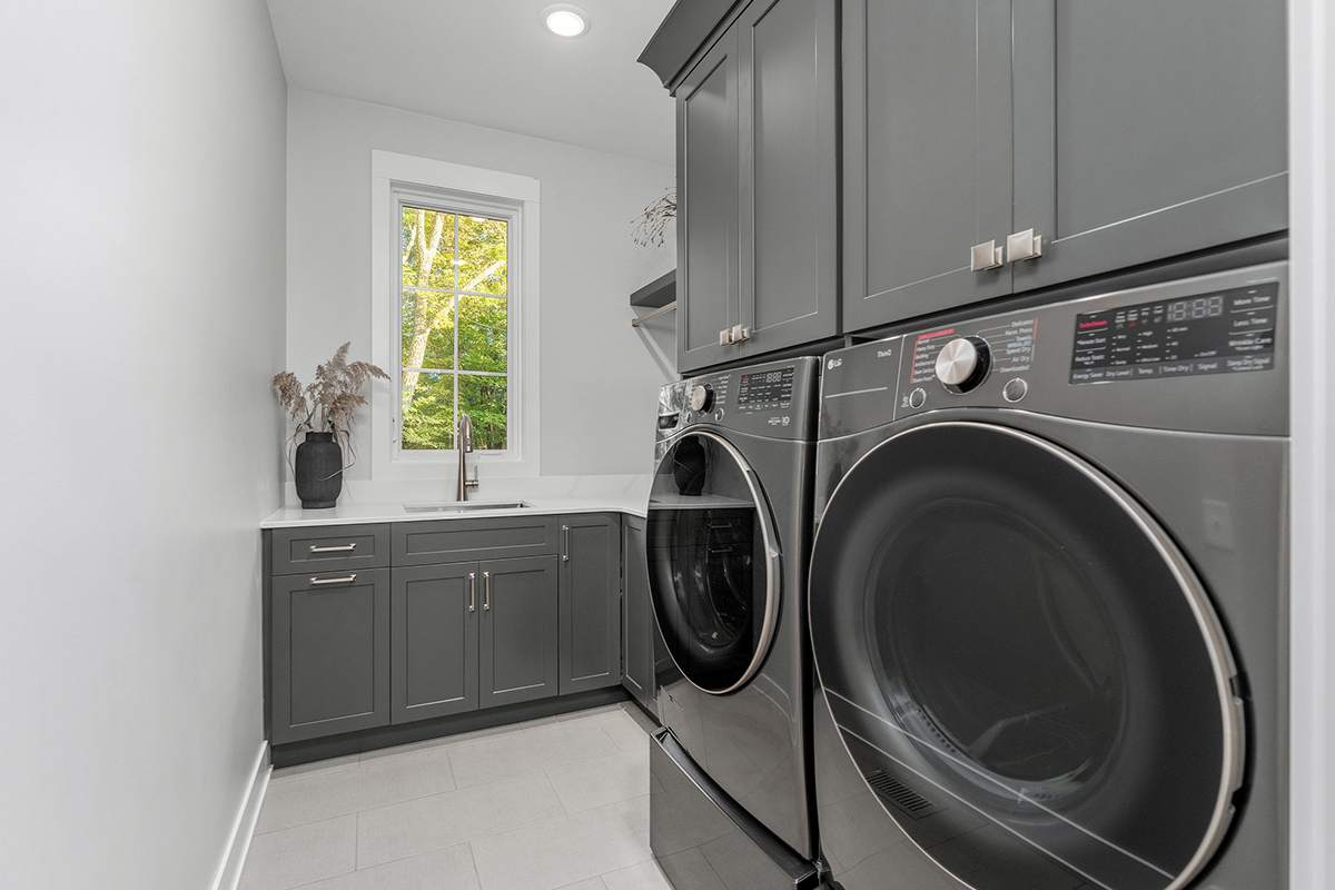 Painted laundry room cabinets and washer/dryer