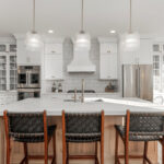 White kitchen cabinets with stained island