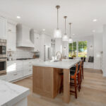 White painted kitchen cabinets with stained island