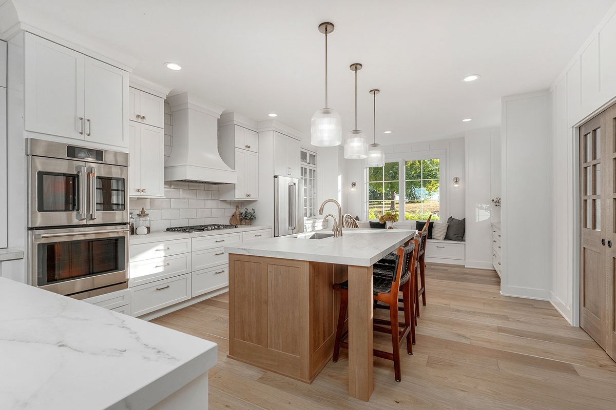 White painted kitchen cabinets with stained island