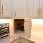 painted kitchen cabinets with door of a countertop appliance storage open