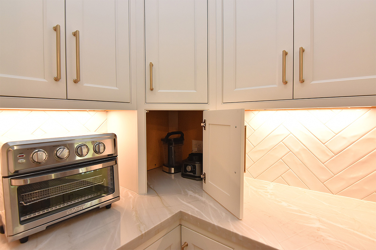 painted kitchen cabinets with door of a countertop appliance storage open