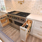 painted pullout storage cabinets pulled out on each side of a stove