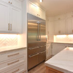 painted kitchen cabinets surrounding a large fridge