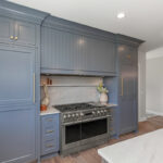 Kitchen with painted perimeter cabinets and stained island cabinets