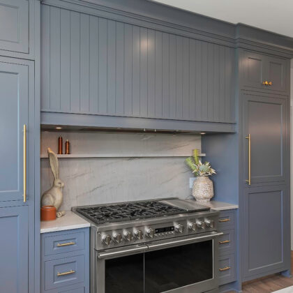 painted kitchen cabinets with wood range hood over an oven