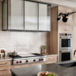 Stained kitchen and white hood with a glass casing over cooktop