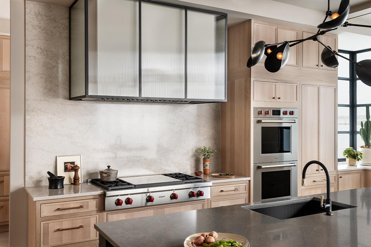 Stained kitchen and white hood with a glass casing over cooktop