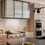 Stained kitchen and white hood with a glass casing over cooktop