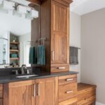 Walnut bathroom cabinets with 2 sinks and countertop storage on each end.