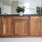 Walnut bathroom cabinets with 2 sinks and countertop storage on each end.