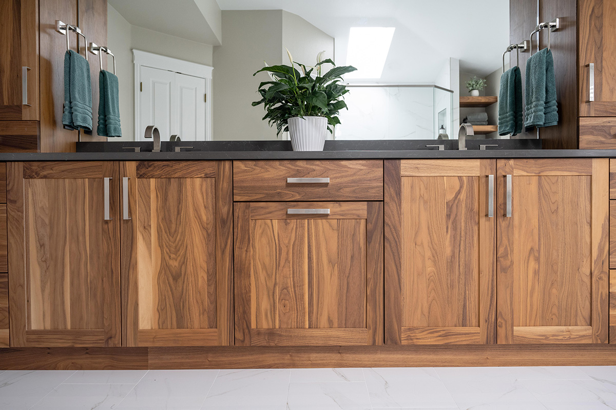 Walnut bathroom cabinets with 2 sinks and countertop storage on each end.