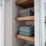 linen closet with stained shelves holding towels