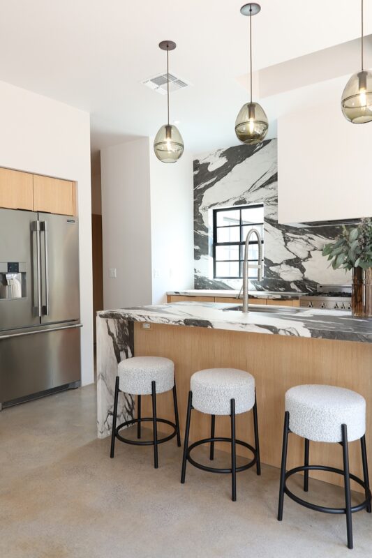 Contemporary kitchen with stained cabinets and marble backsplash