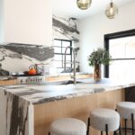 Contemporary kitchen with stained cabinets and marble backsplash