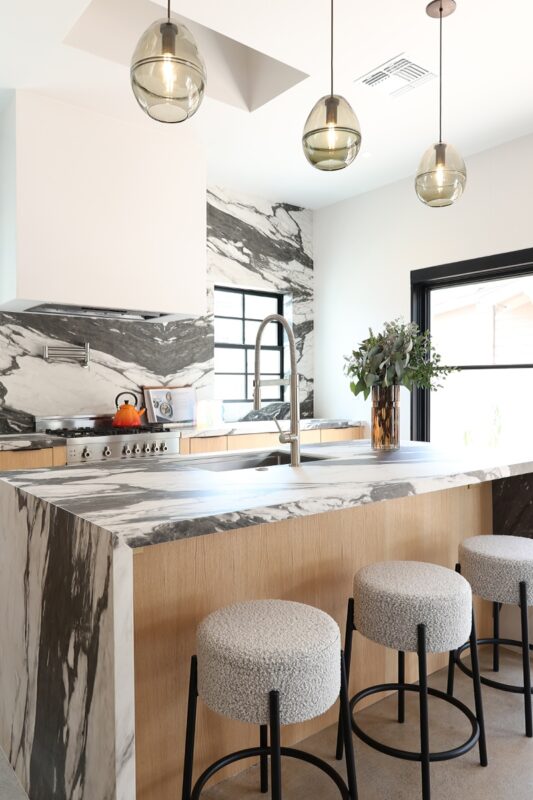 Contemporary kitchen with stained cabinets and marble backsplash