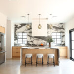 Contemporary kitchen with stained cabinets and marble backsplash