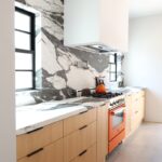 Contemporary kitchen with stained cabinets and marble backsplash
