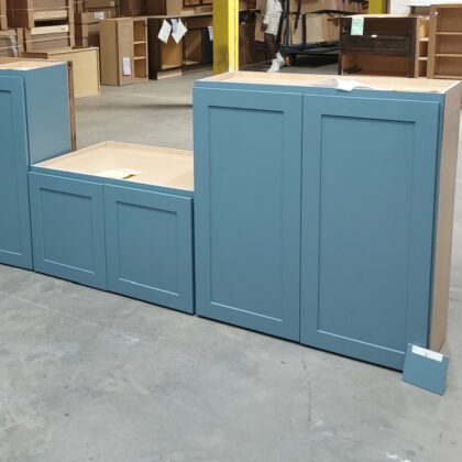 Blue painted wall cabinets on the floor of a warehouse