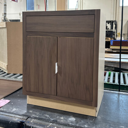 Base cabinet in the Milan slab door style finished with Sable stain on walnut.