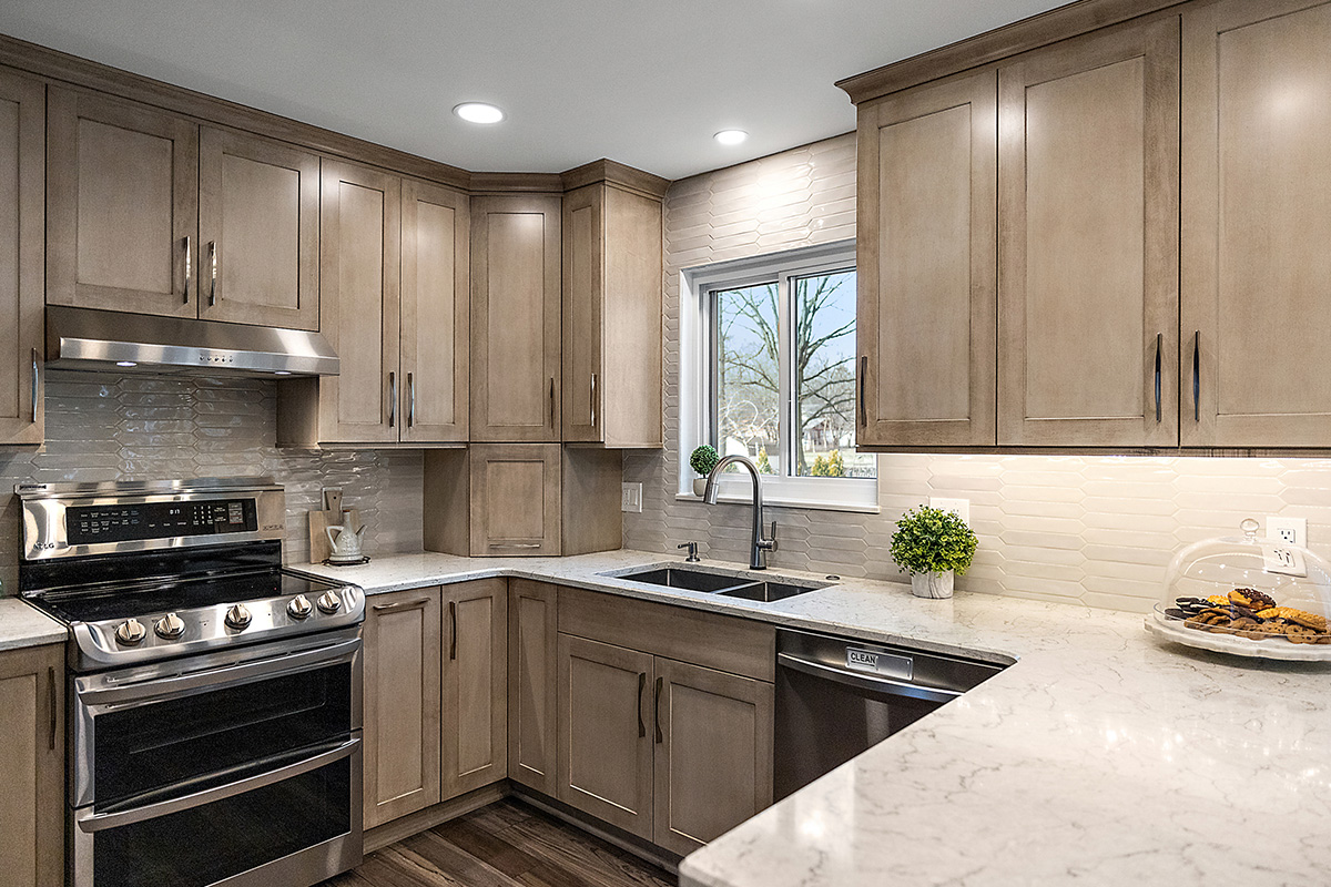 Kitchen cabinets stained in light Montana stain on maple. View includes a stove and dishwasher.