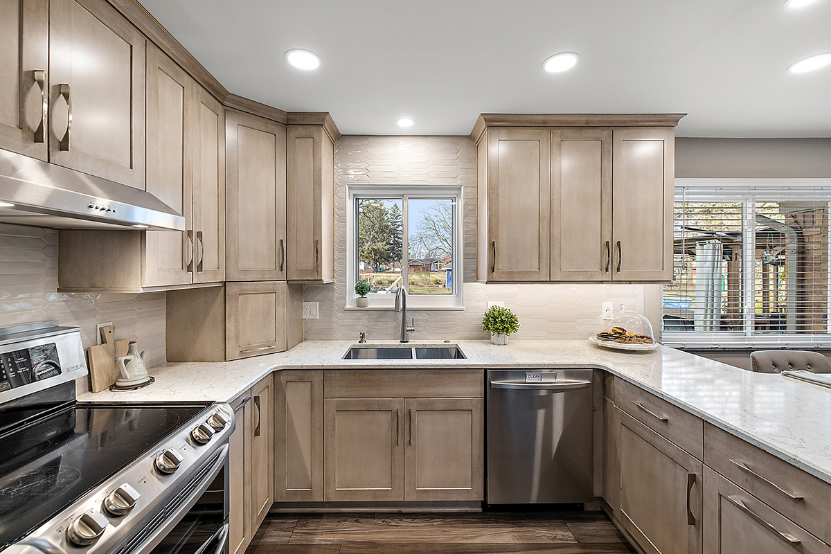 Kitchen cabinets stained in light Montana stain on maple. View includes a stove and dishwasher.