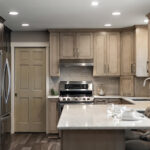 Kitchen cabinets stained in light Montana stain on maple. View includes a stove and dishwasher.