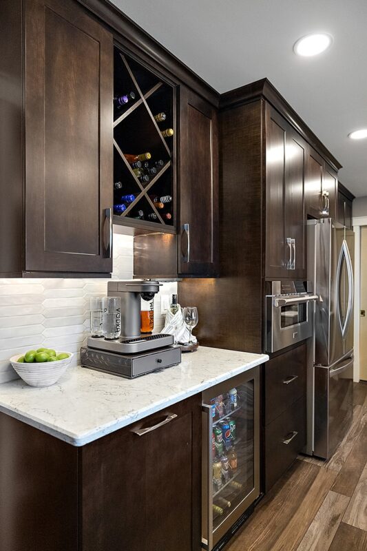 Coffee bar area in rich Espress stain. Includes a view of a countertop coffee machine and wine rack above.