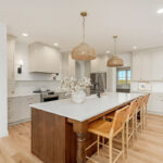 White painted kitchen cabinets and stained island.
