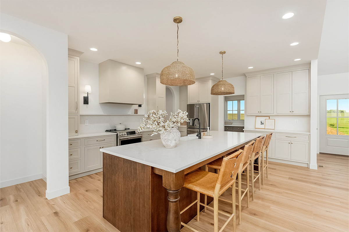 White painted kitchen cabinets and stained island.