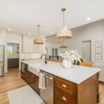 White painted kitchen cabinets and stained island.
