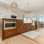 White painted kitchen cabinets and stained island.