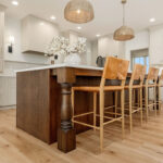 White painted kitchen cabinets and stained island.