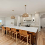 White painted kitchen cabinets and stained island.