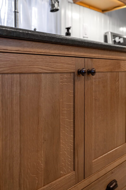 Stained cabinets in a narrow kitchen. Cabinets made with quartersawn white oak stained with Buff finish.