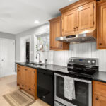 Stained cabinets in a narrow kitchen. Cabinets made with quartersawn white oak stained with Buff finish.