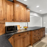 Stained cabinets in a narrow kitchen. Cabinets made with quartersawn white oak stained with Buff finish.