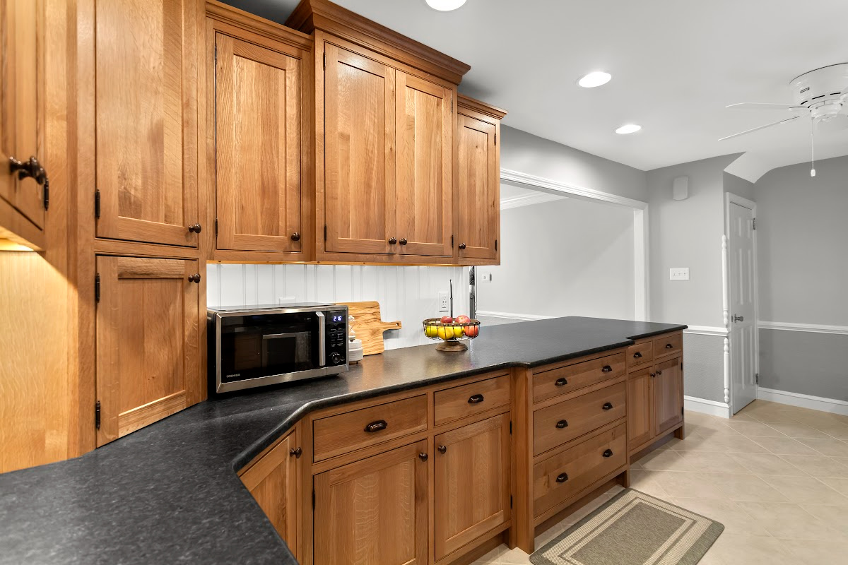 Stained cabinets in a narrow kitchen. Cabinets made with quartersawn white oak stained with Buff finish.