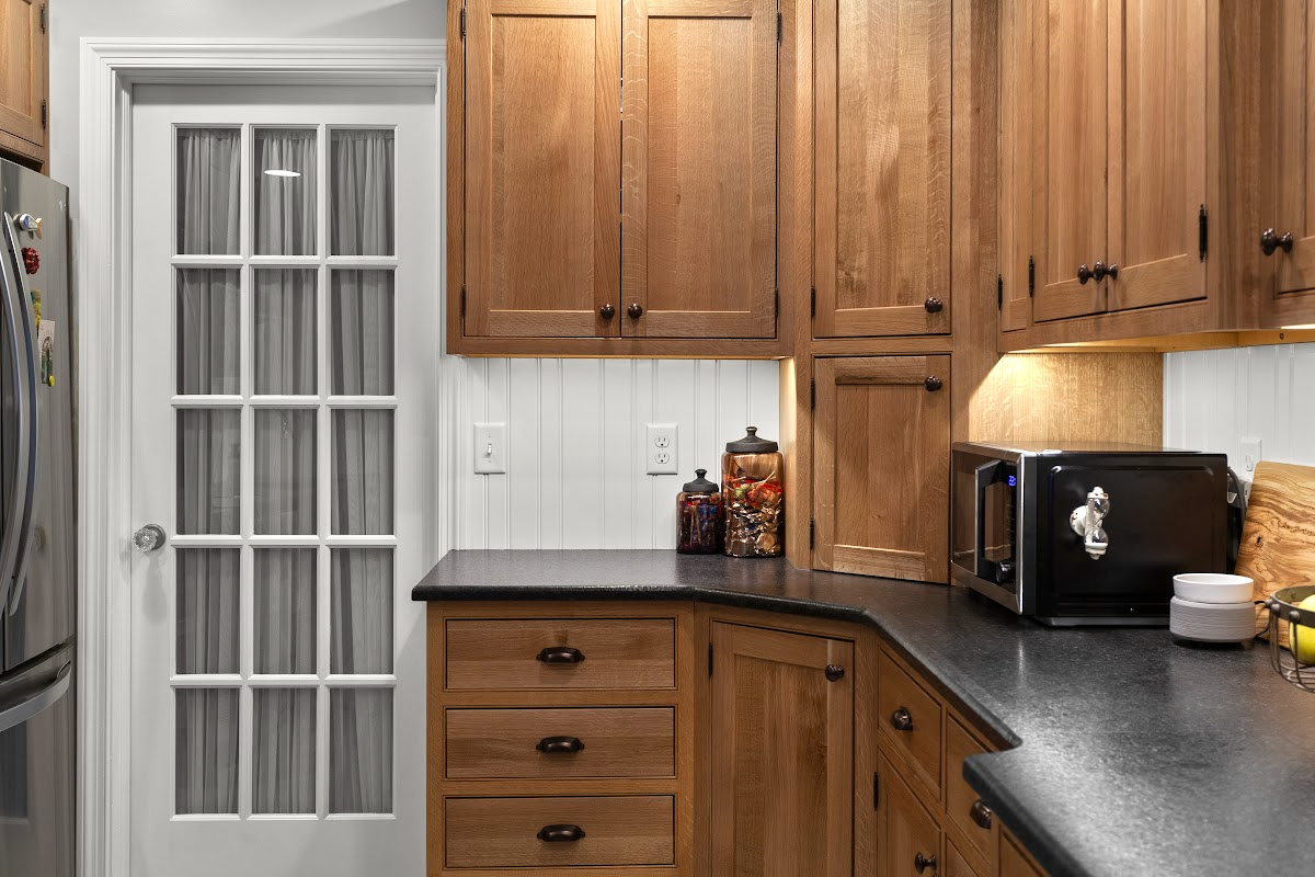 Stained cabinets in a narrow kitchen. Cabinets made with quartersawn white oak stained with Buff finish.