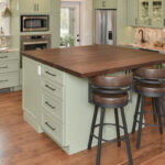 Painted kitchen cabinets in a mint green color. Shows island with stools.
