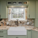 Painted kitchen cabinets in a mint green color. View of window over sink.
